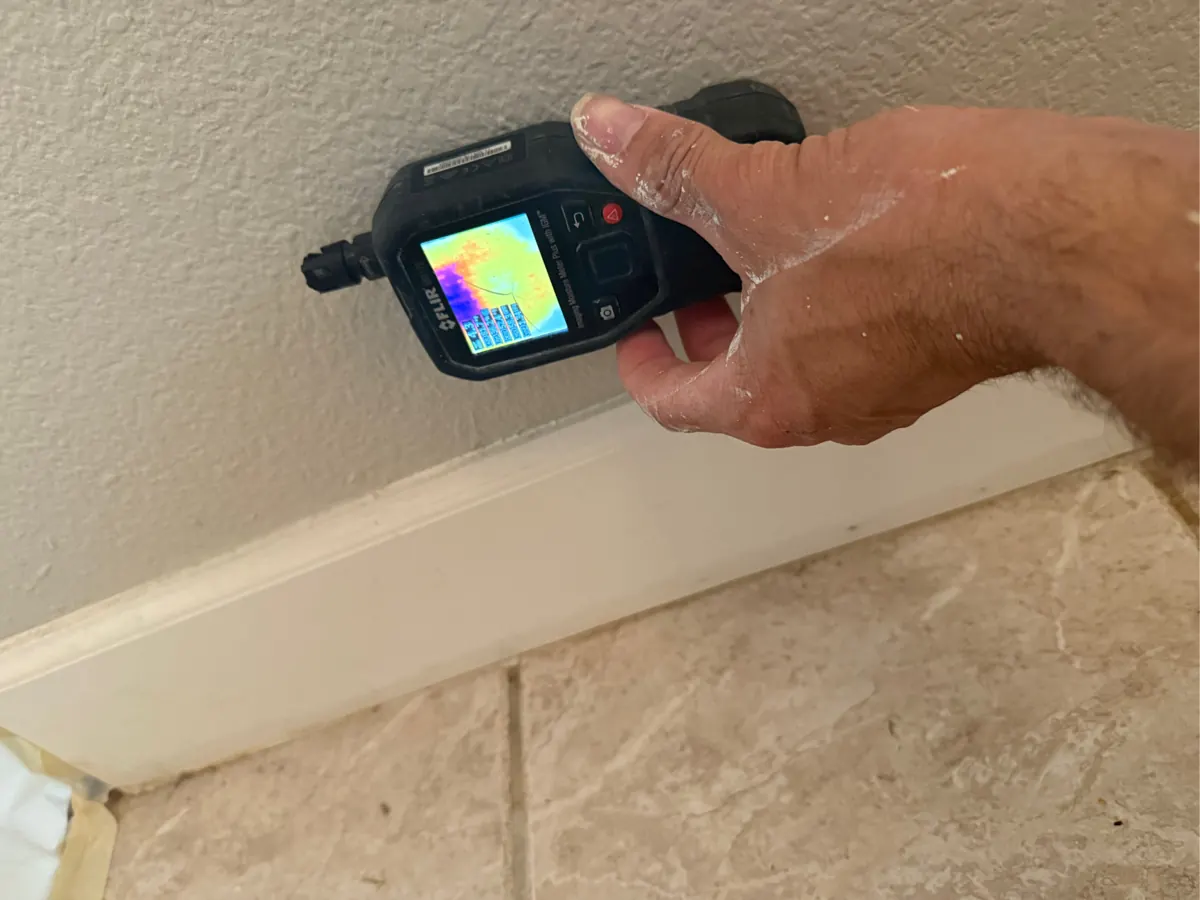 Thermal moisture meter on a wall above the baseboard in an Anthem home