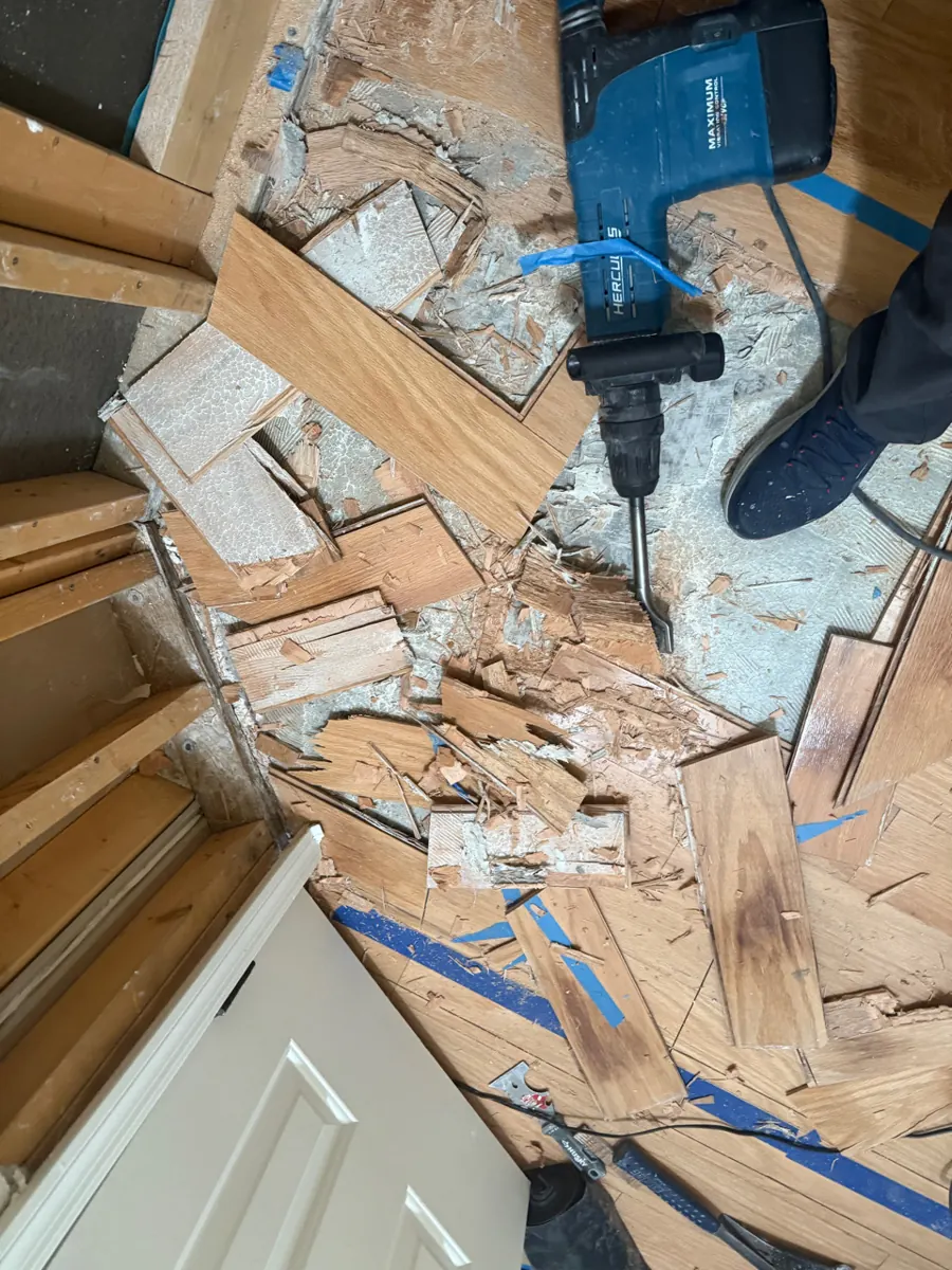 Before: wood flooring being broken up and removed in an Anthem bedroom