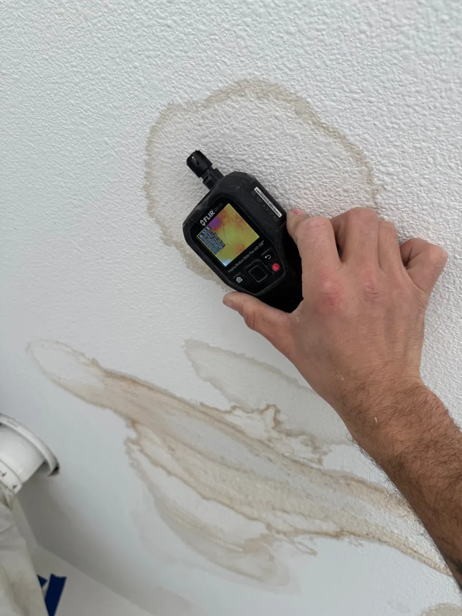 Thermal moisture meter pressed to a stained garage ceiling in a Centennial Hills home