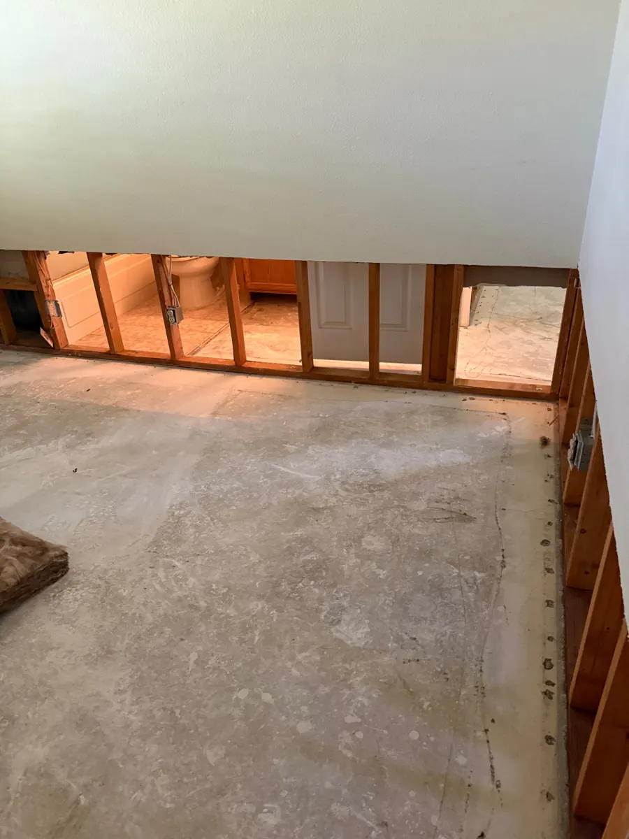 Before: lower drywall cut out to the studs over a bare concrete slab in a Centennial Hills home