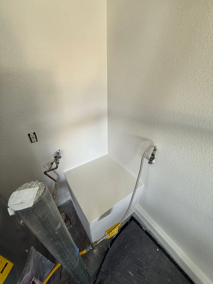 After: textured white walls and rebuilt water heater stand in a Centennial Hills utility area
