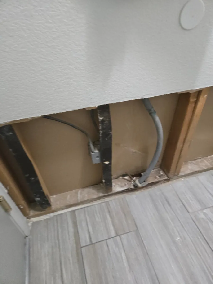Lower drywall removed to show stained studs over a tile floor in a Foothills home