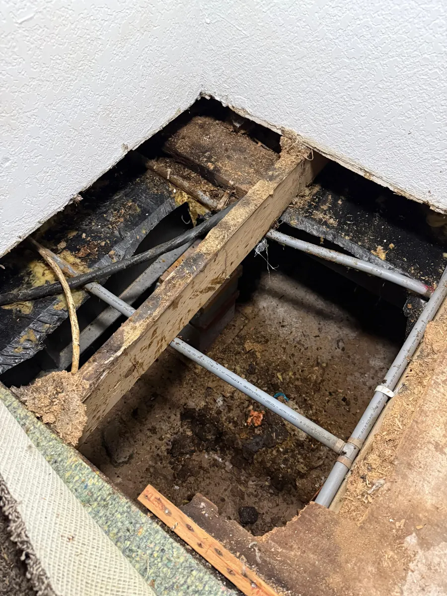 Floor cut open to expose framing and pipes in a Green Valley South home