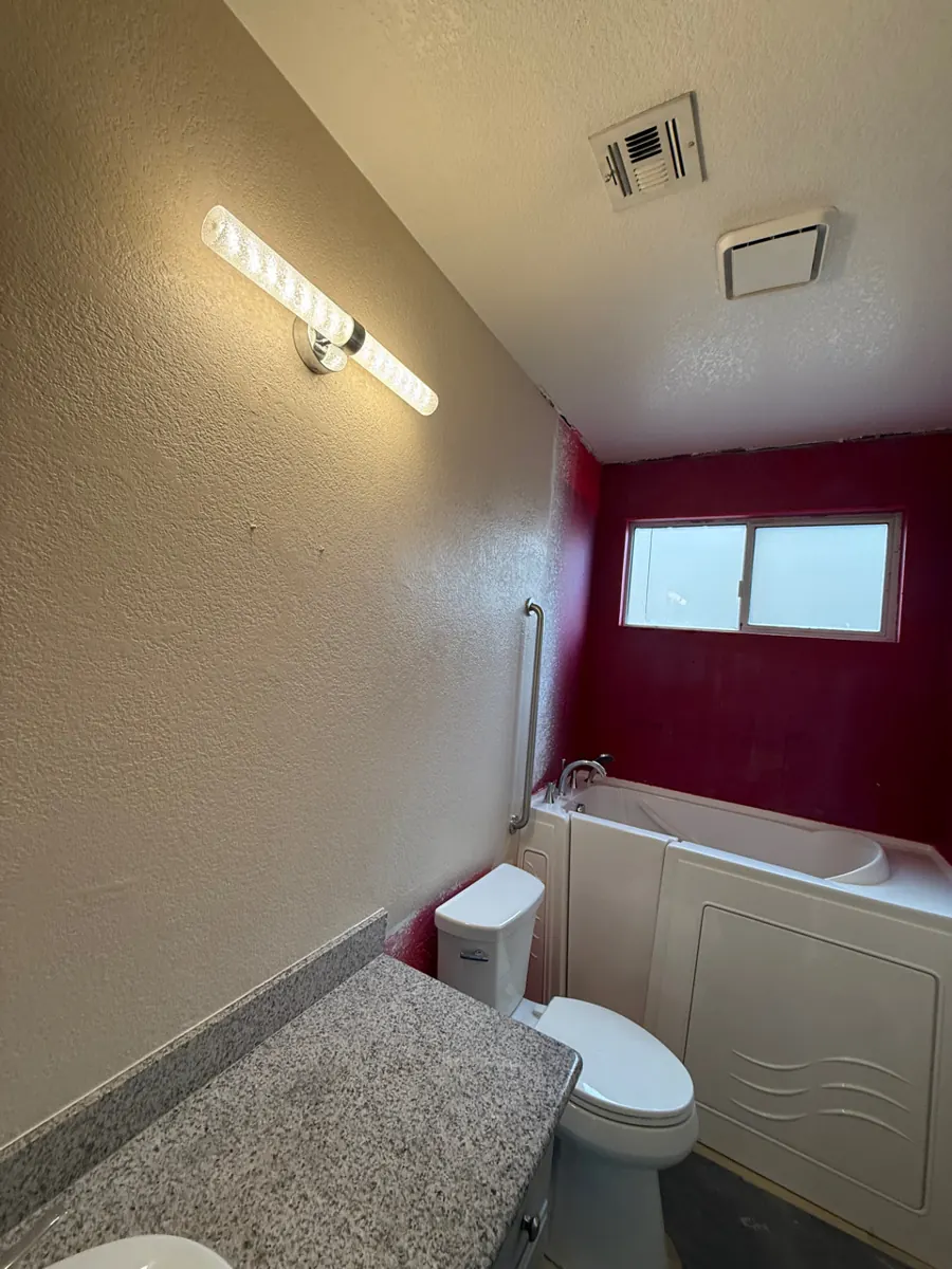 Finished bathroom with walk-in tub, grab bar and vanity light in Green Valley North