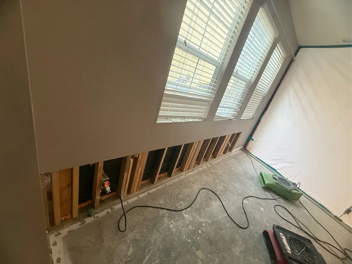 Lower drywall cut out to the studs along a living room wall in an Inspirada home