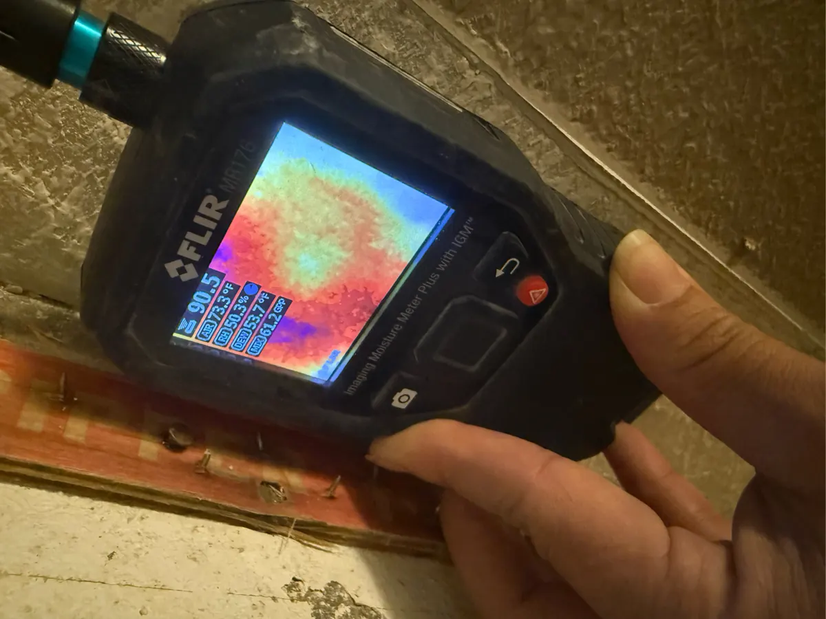 Thermal moisture meter scanning a wall base in an Inspirada home