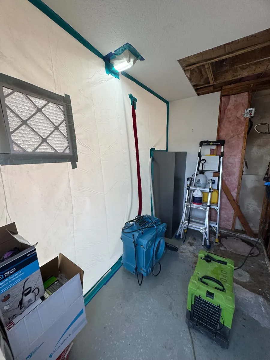 Plastic containment with a zipper door and drying equipment in a Lake Havasu City garage