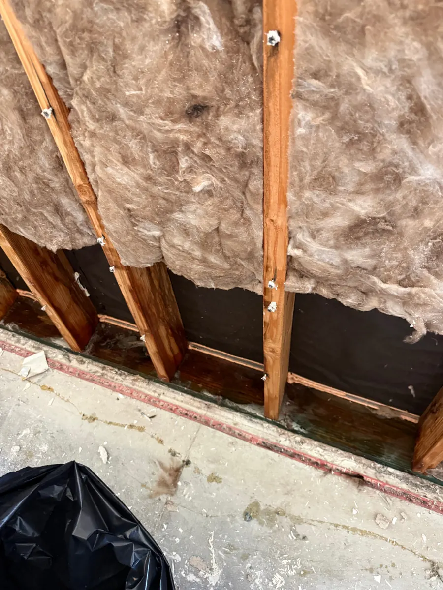 Wall opened to studs and insulation during water damage work in Lake Las Vegas