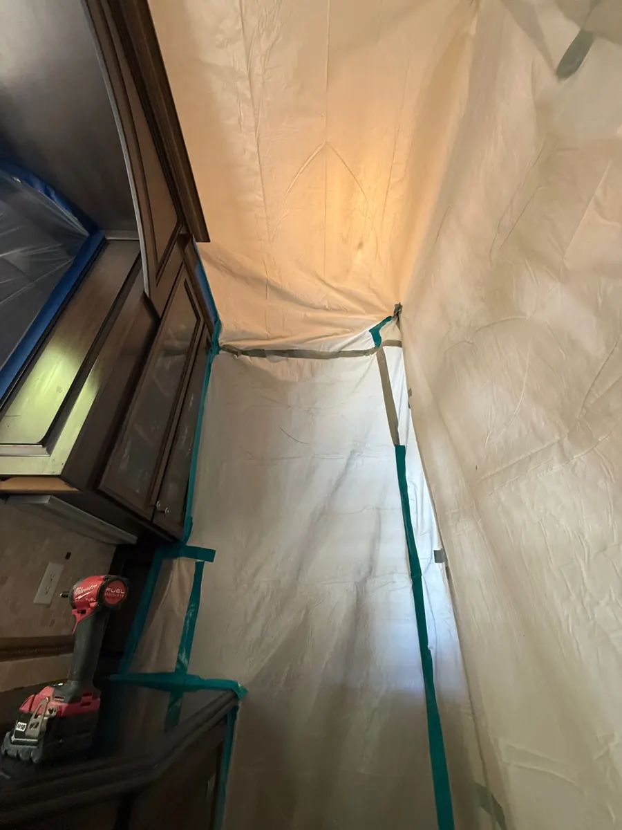 Plastic containment taped around kitchen cabinets in a MacDonald Ranch home