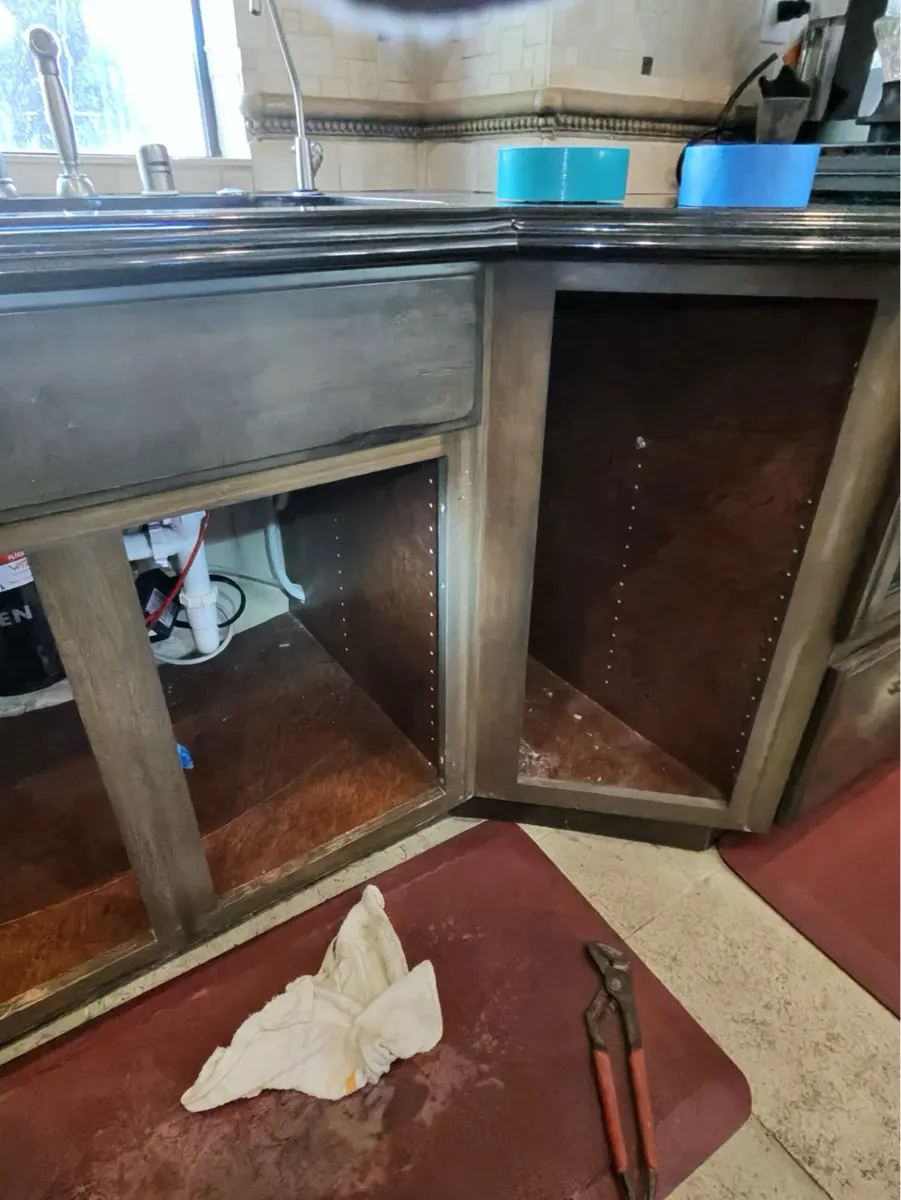 Kitchen sink cabinets emptied for inspection in a Roma Hills, MacDonald Ranch home