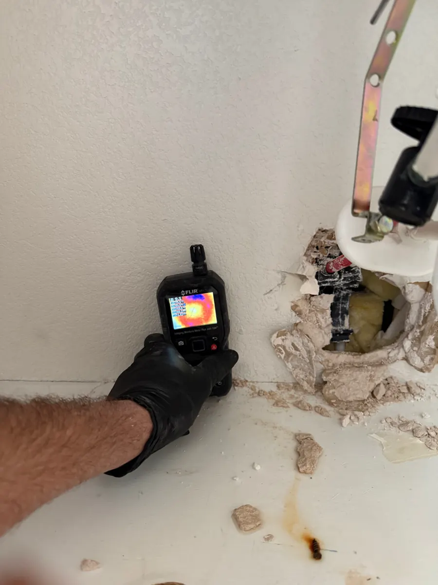Thermal moisture meter at a bathroom wall after vanity removal in Sunridge Heights