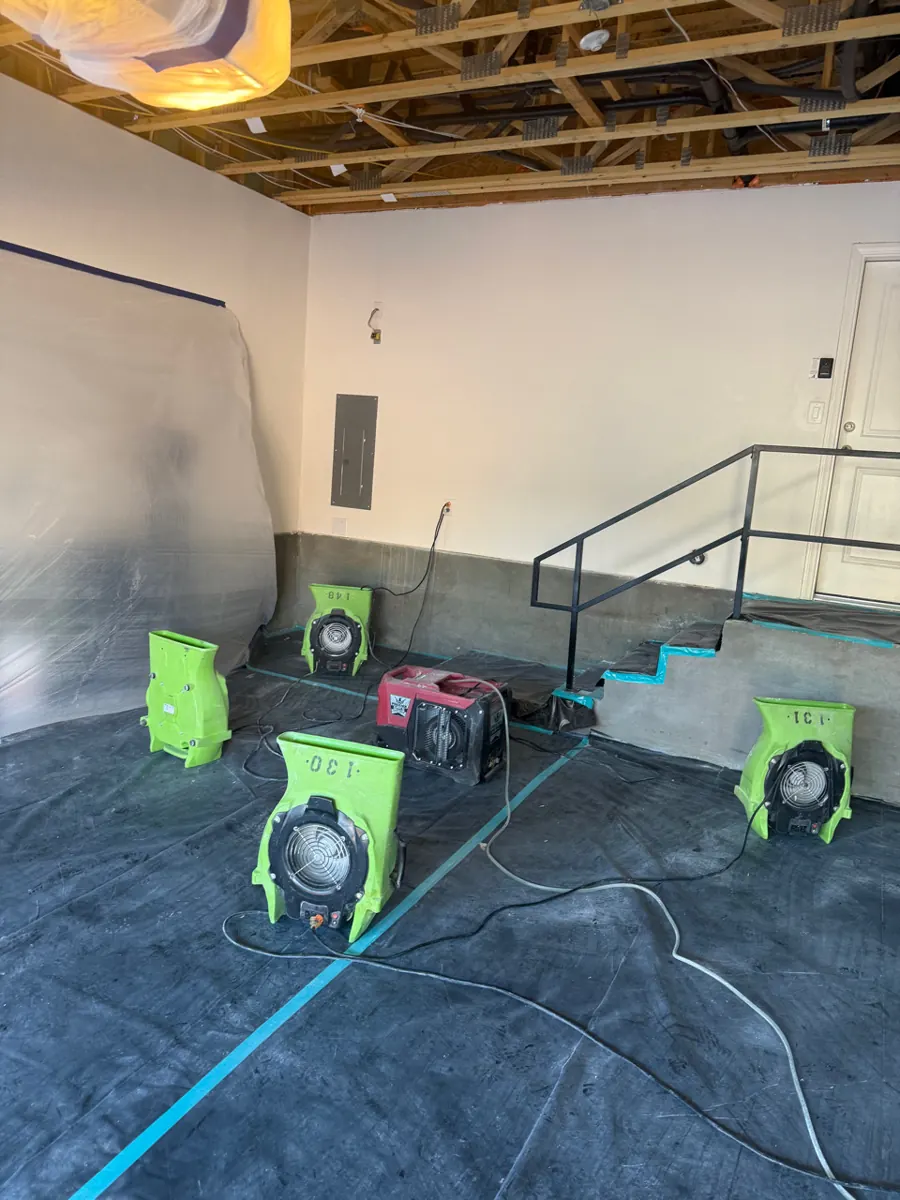 Air movers and a dehumidifier on a covered garage floor in a McCullough Hills townhome