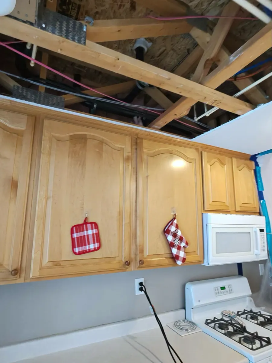 Kitchen ceiling opened to joists above wood cabinets in a North Las Vegas home