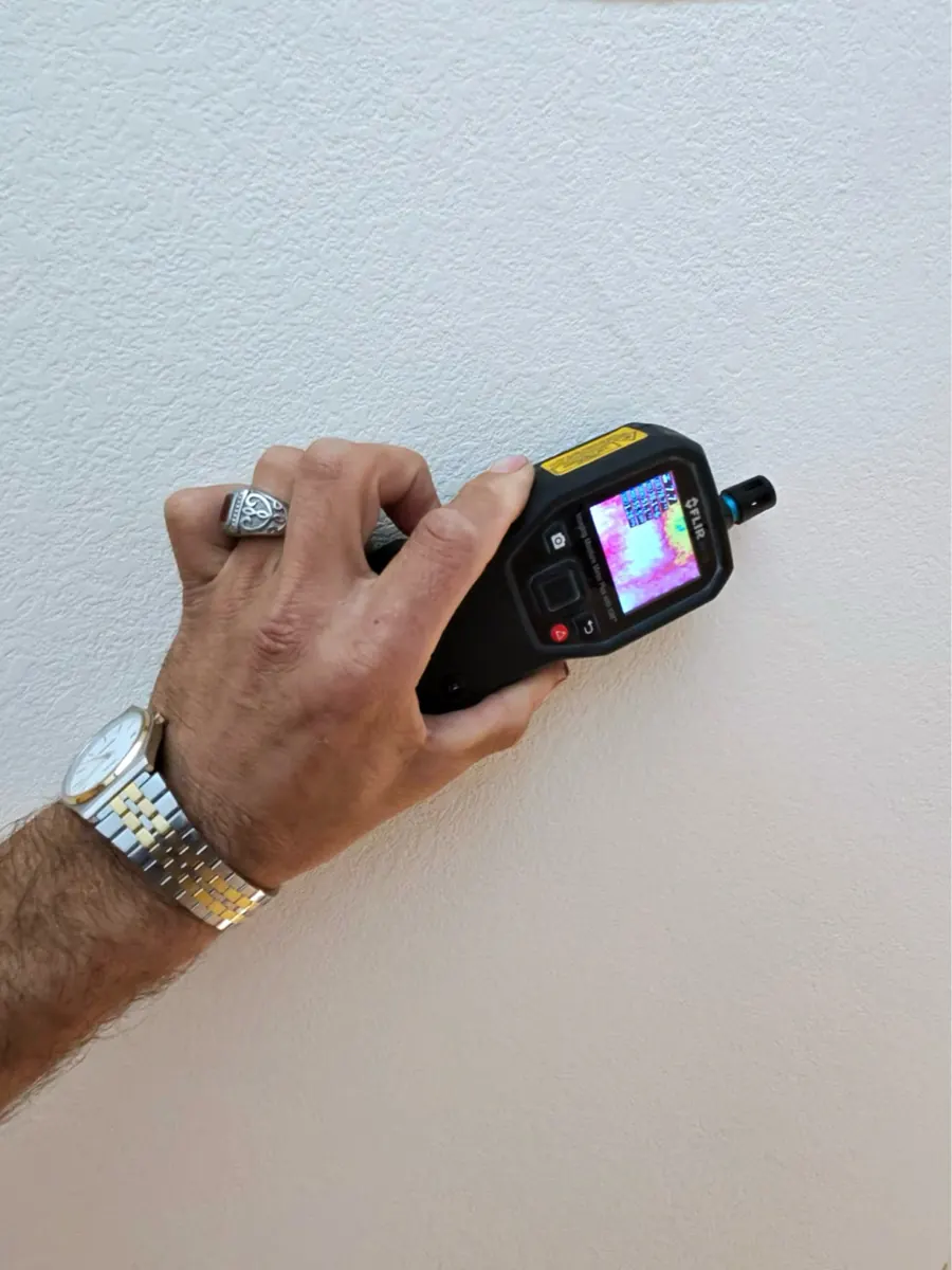 Thermal moisture meter held to a kitchen wall in a North Las Vegas home