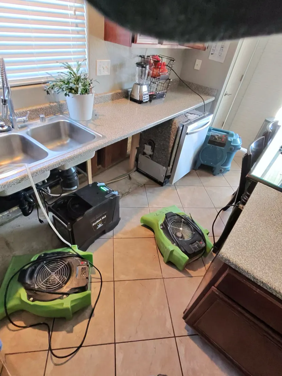 Air movers and a dehumidifier under the kitchen counters in a Northwest Las Vegas home