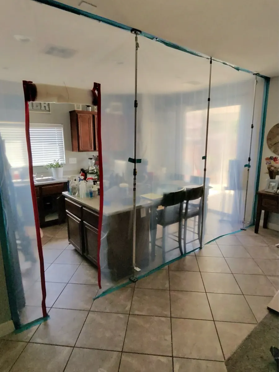 Plastic containment wall with zipper doors around a kitchen in a Northwest Las Vegas home