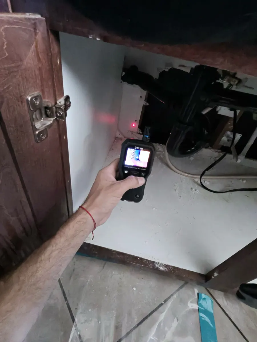 Thermal moisture meter aimed inside a kitchen sink base cabinet in Northwest Las Vegas