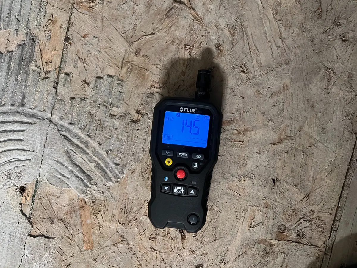 Moisture meter resting on exposed bathroom subfloor in a Northwest Las Vegas home