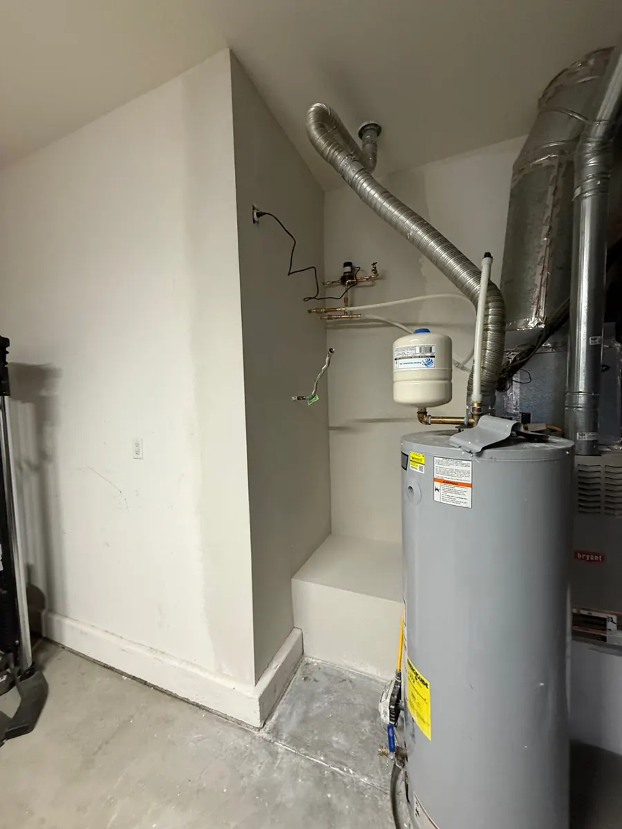 Garage utility closet with new painted drywall beside the water heater near Providence
