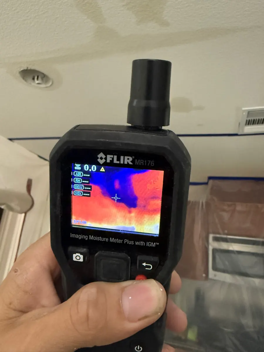 Thermal moisture meter aimed at a stained kitchen ceiling in a Providence home