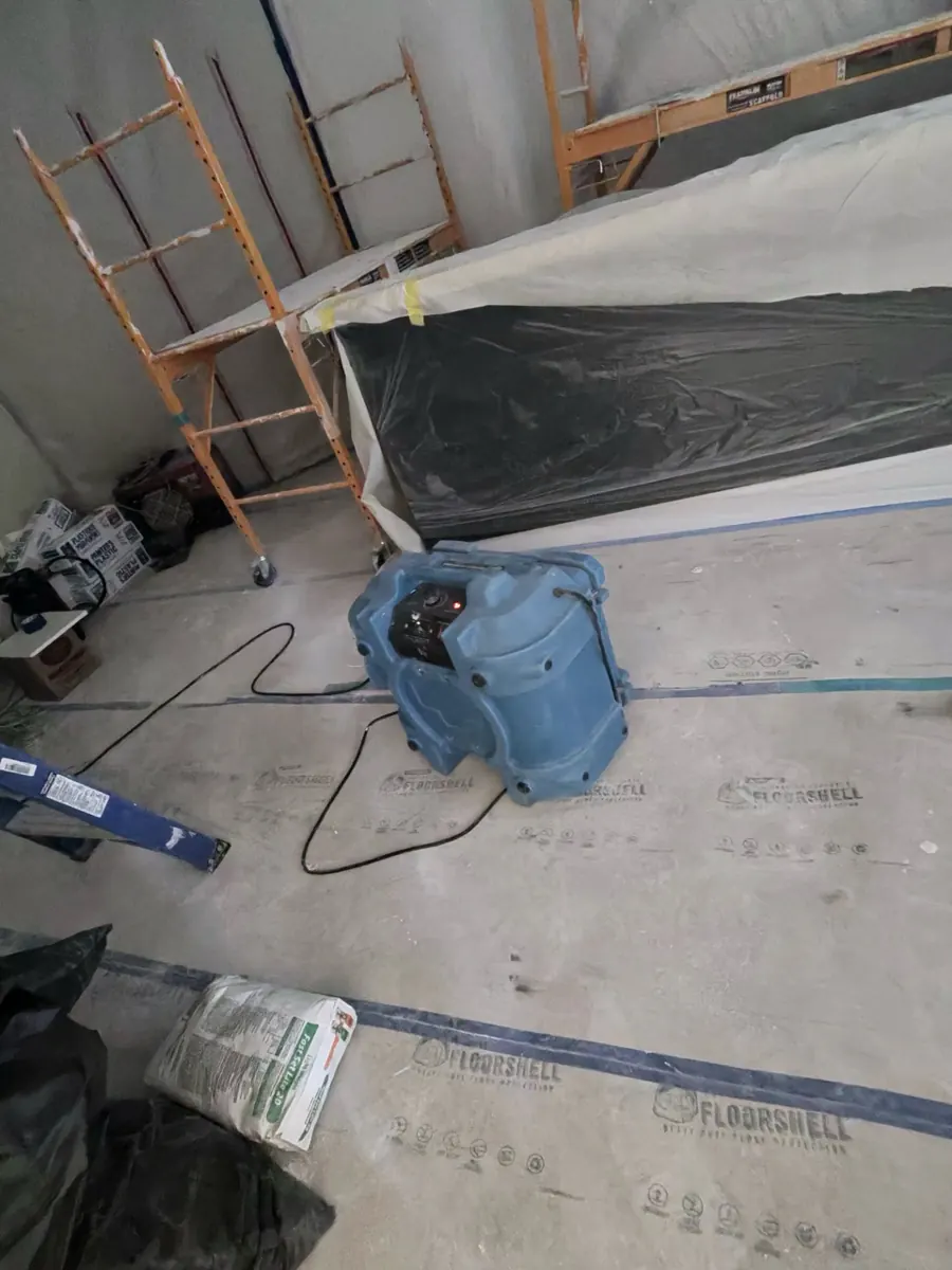Air mover on a protected floor beside scaffolding inside containment near Queensridge