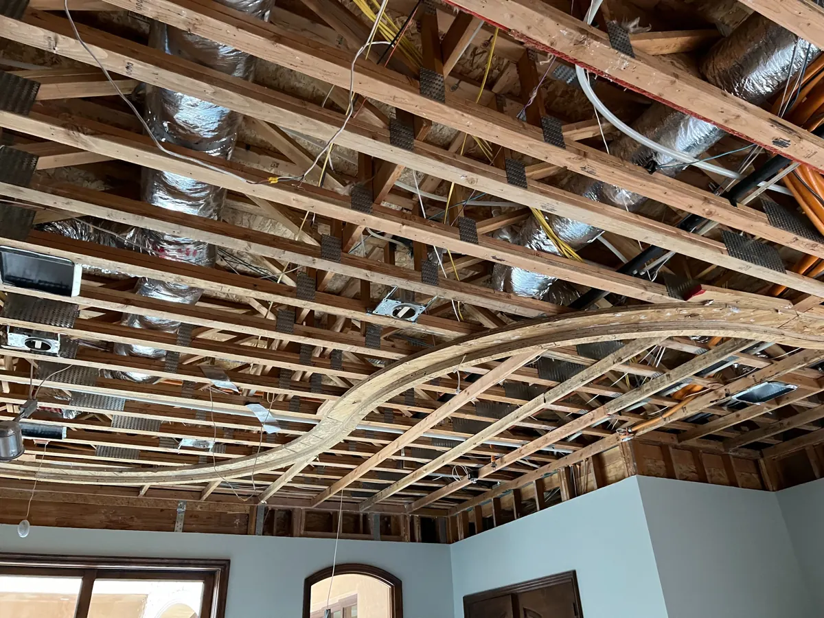 Ceiling opened to the framing with a curved soffit, ducts and wiring exposed in a Red Rock Country Club home
