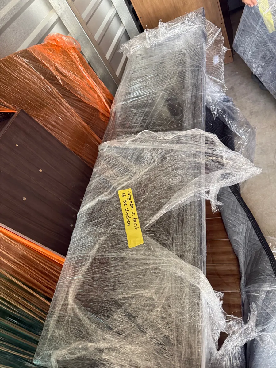 Shrink-wrapped furniture with a room tag in storage after a Red Rock Country Club contents pack-out