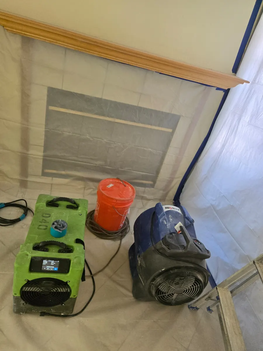 Dehumidifier and air mover on plastic sheeting inside containment in a Silverado Ranch home