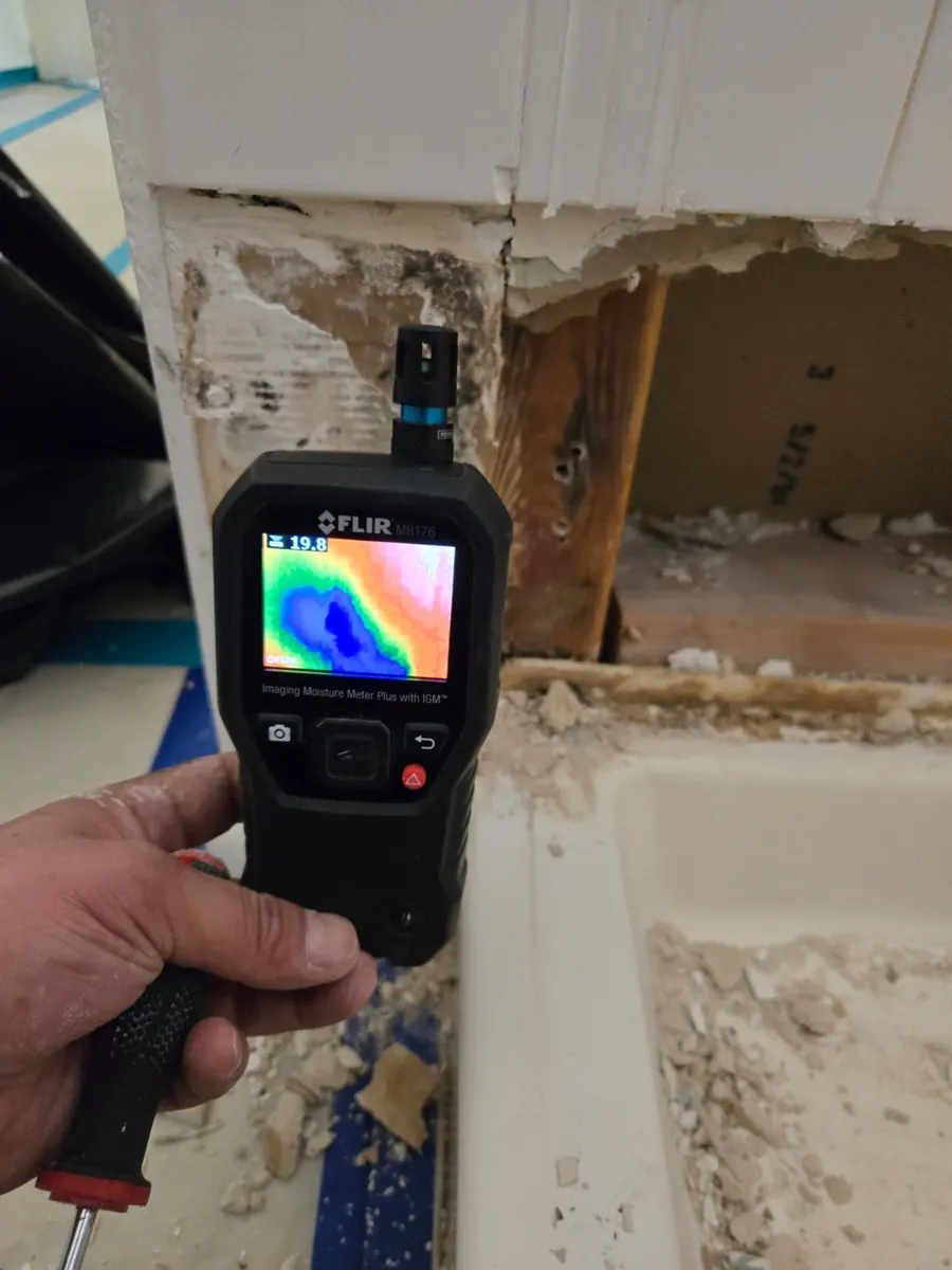 Imaging moisture meter in front of an opened shower wall in a Silverado Ranch home