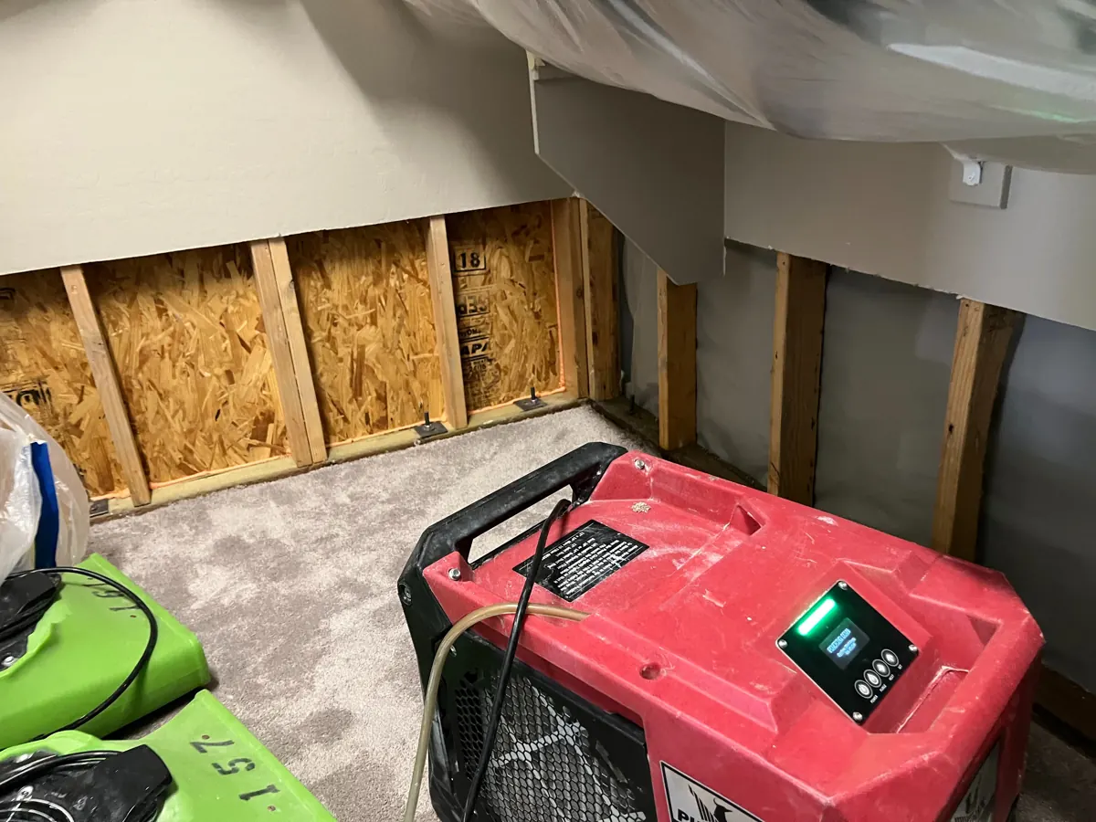 Dehumidifier and air movers in front of opened closet walls in a Skye Canyon home