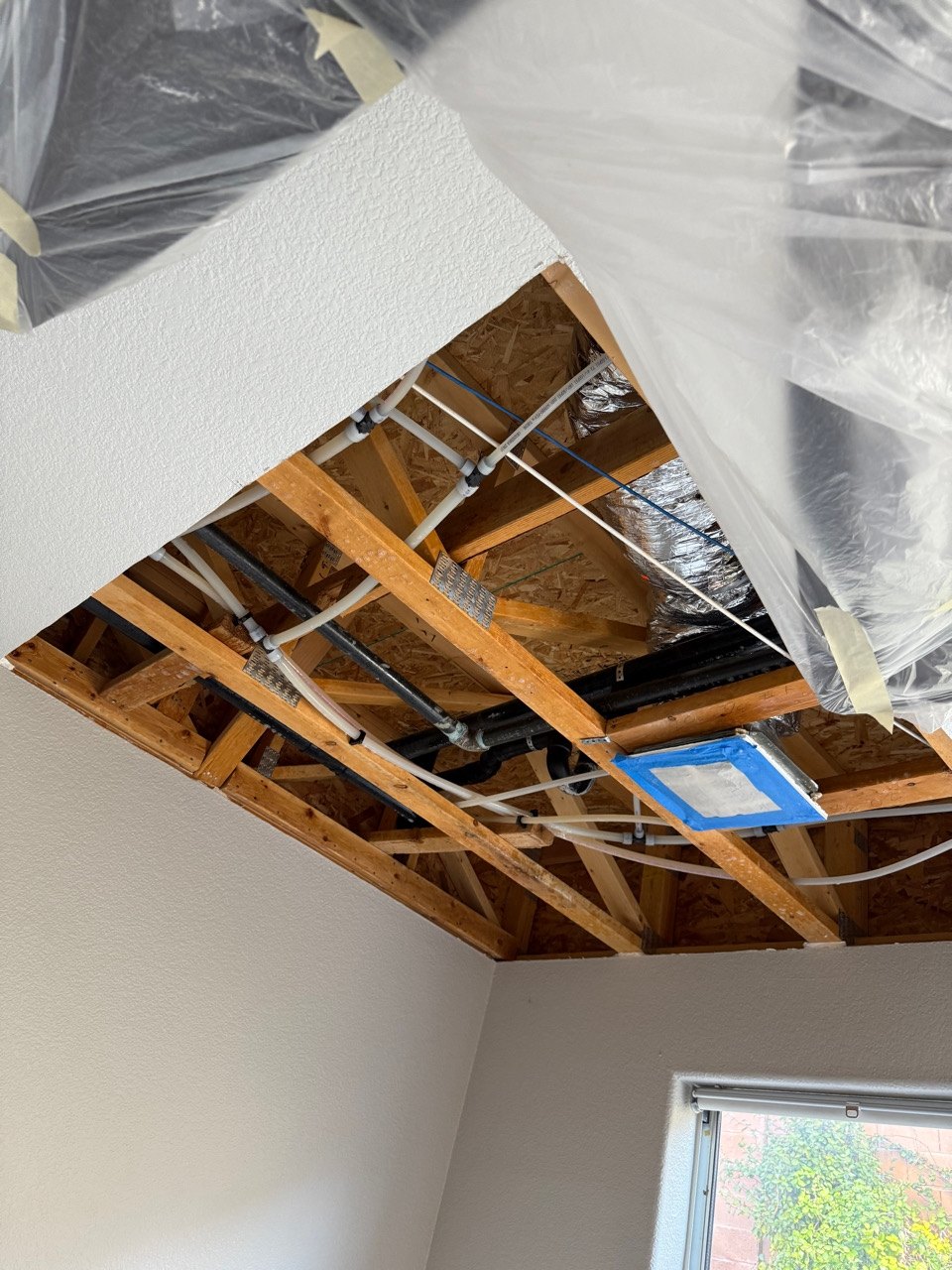 Opened ceiling drywall with framing and plumbing visible inside a Southern Highlands home