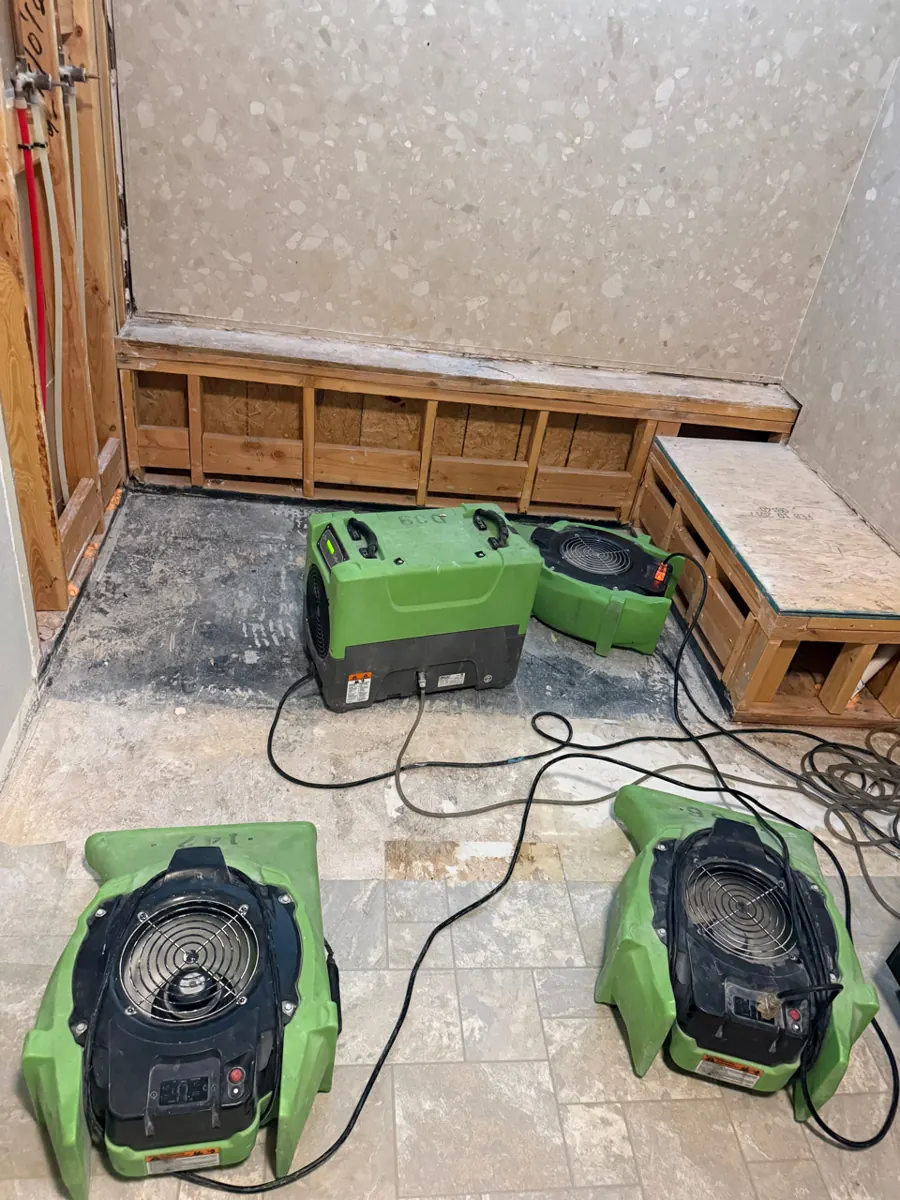 Dehumidifier and air movers set in an opened walk-in shower in a Southern Highlands home