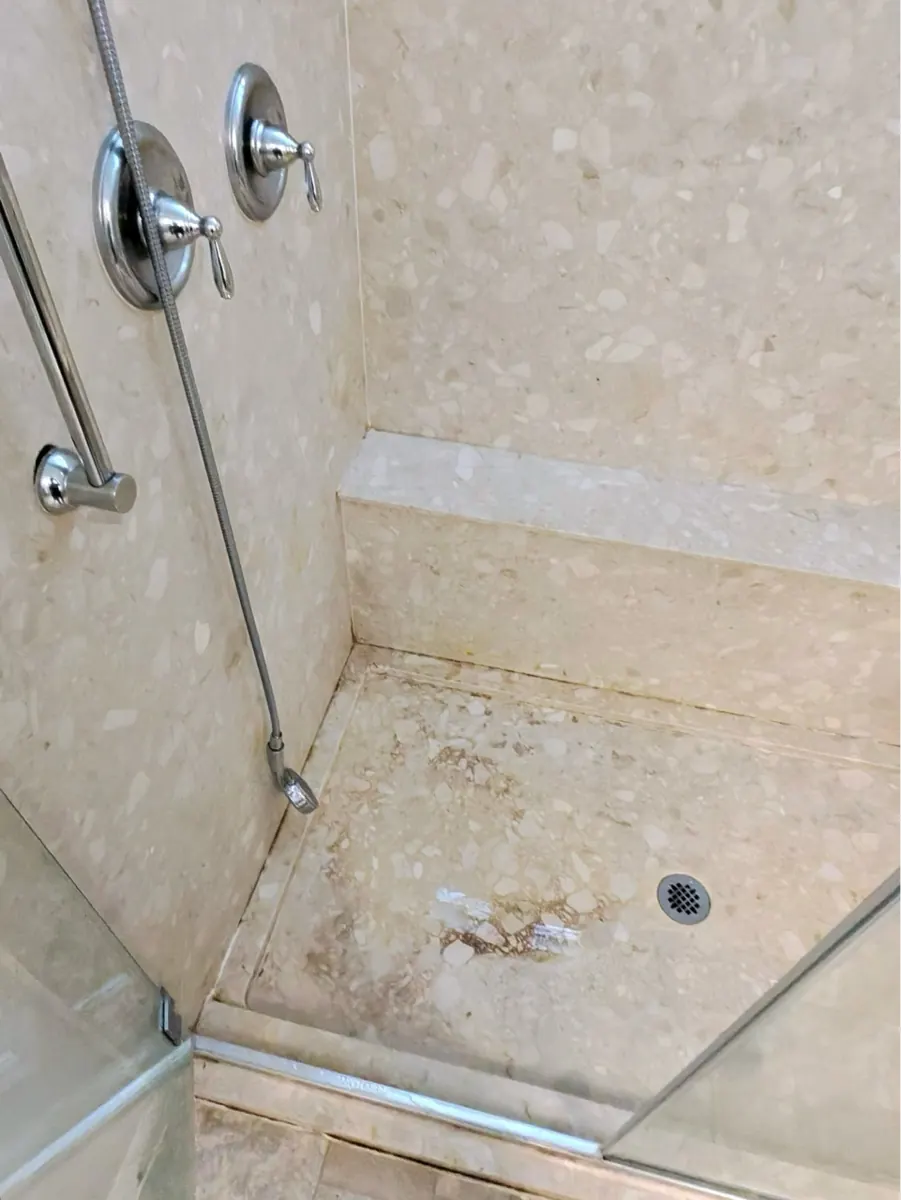 Walk-in shower pan with brown staining near the drain in a Southern Highlands bathroom