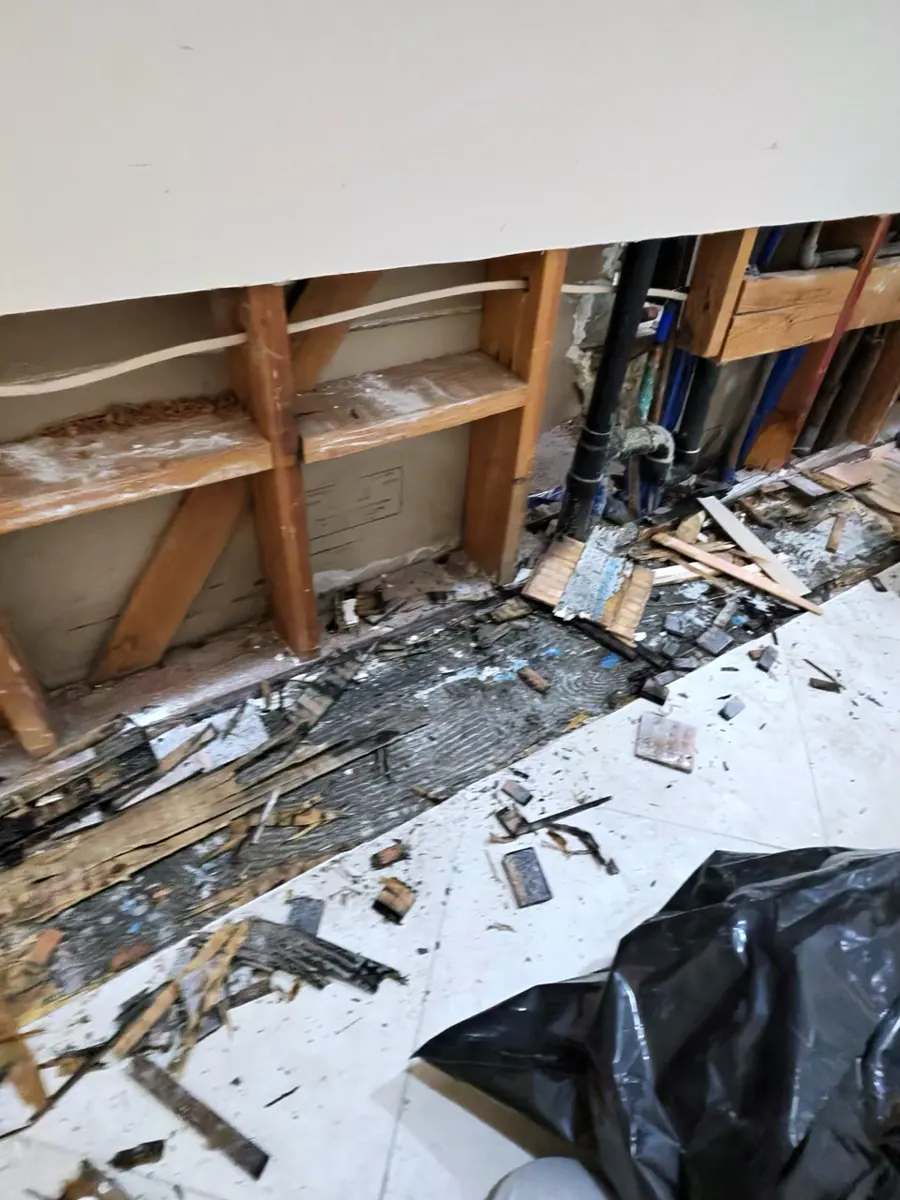 Built-in cabinet bases removed to expose framing and plumbing in a Spring Valley dining room