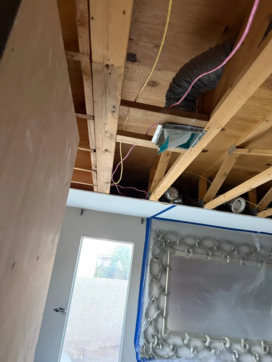 Ceiling opened to the joists, wiring and a flex duct in a two-story home in The Lakes