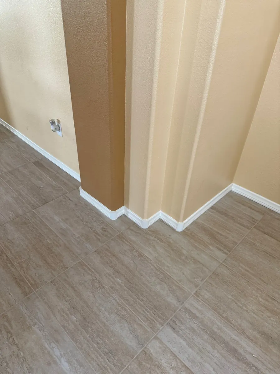Rebuilt wall corner with new baseboard and tile flooring in a home in The Trails
