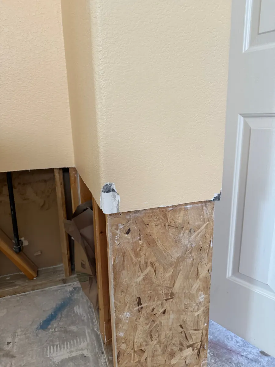 Hallway wall corner cut open to framing and sheathing during repairs in The Trails