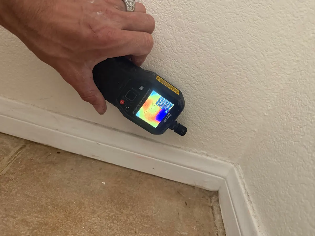 Thermal moisture meter reading at a baseboard in a home in The Trails, Summerlin