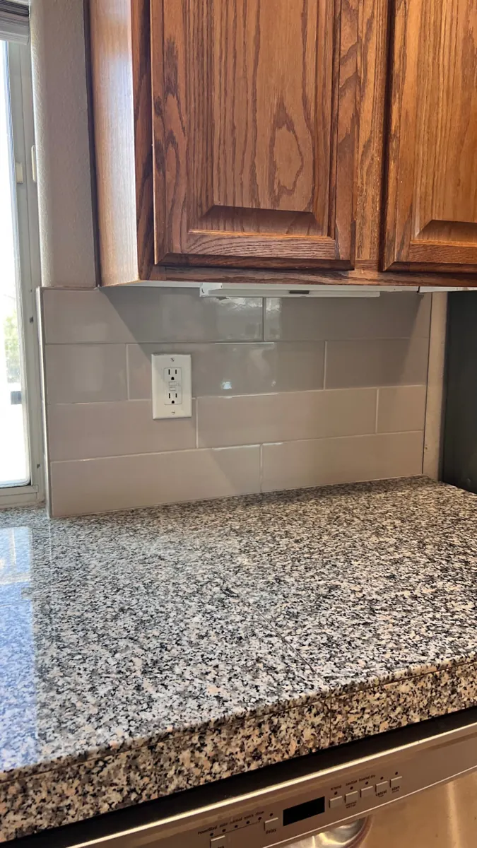 Close view of gray subway tile cut around an outlet in a West Henderson kitchen