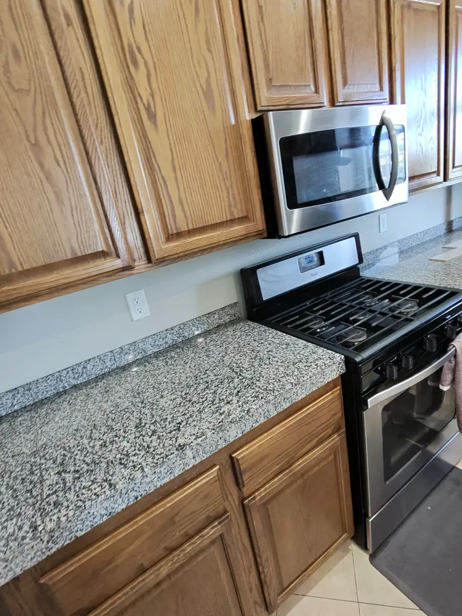 Granite kitchen counters with a bare painted wall above in a West Henderson home