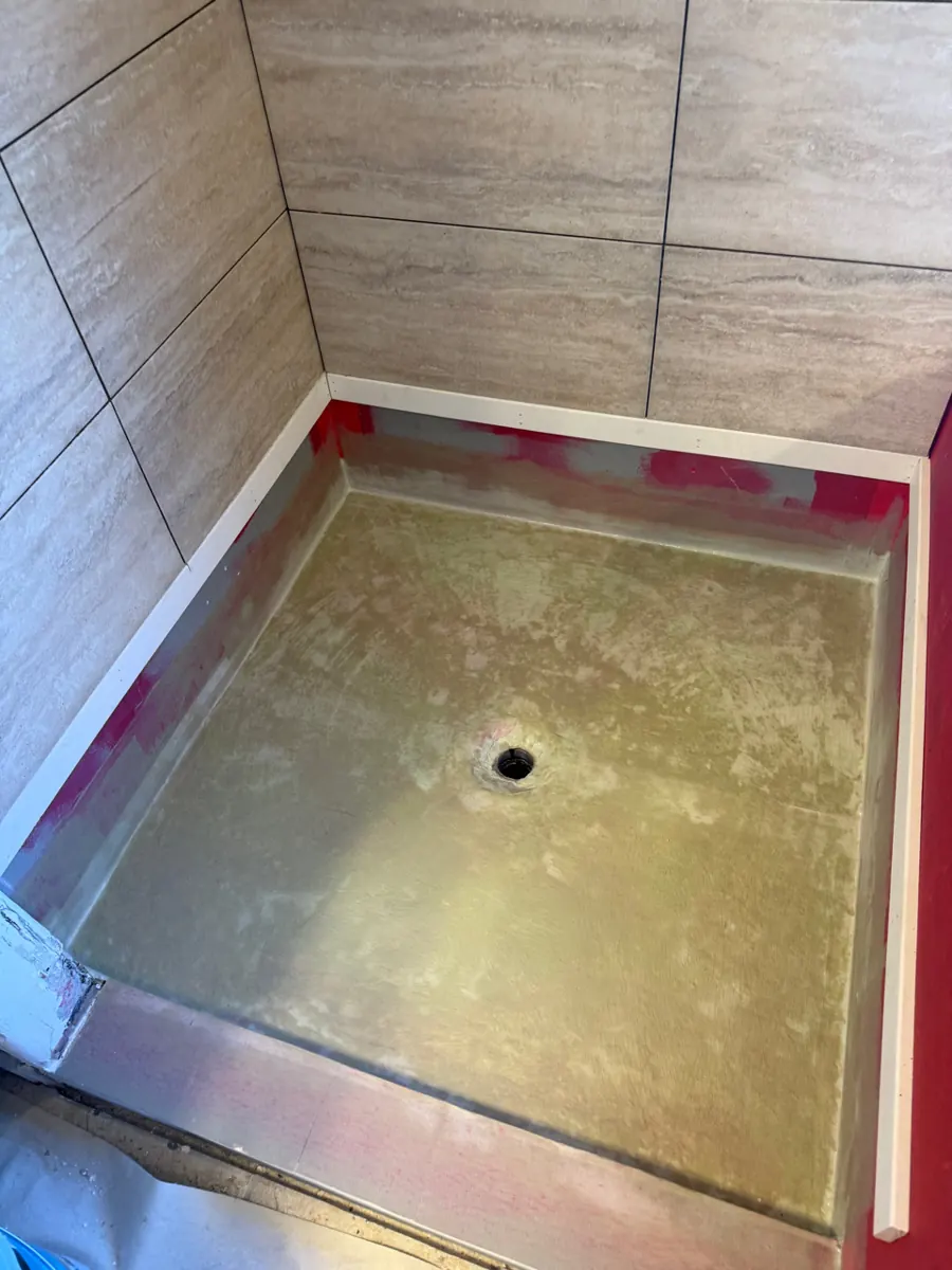 Waterproofed shower pan with new wall tile above it in a West Henderson bathroom