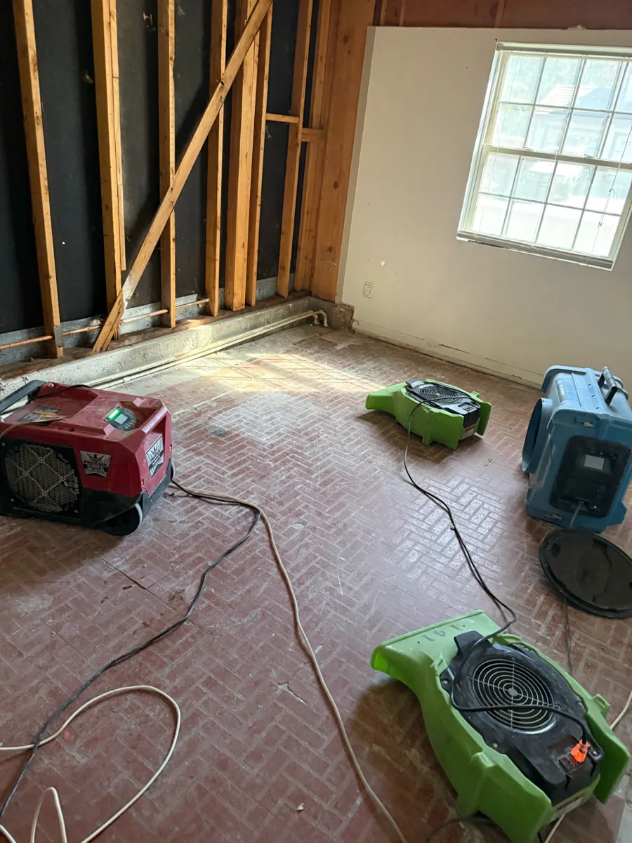 Dehumidifier and air movers running on the floor of an opened room in West Sahara