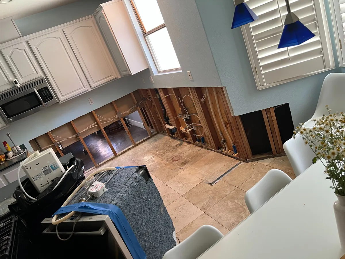 Kitchen with lower cabinets out and walls cut open to studs and plumbing in West Sahara