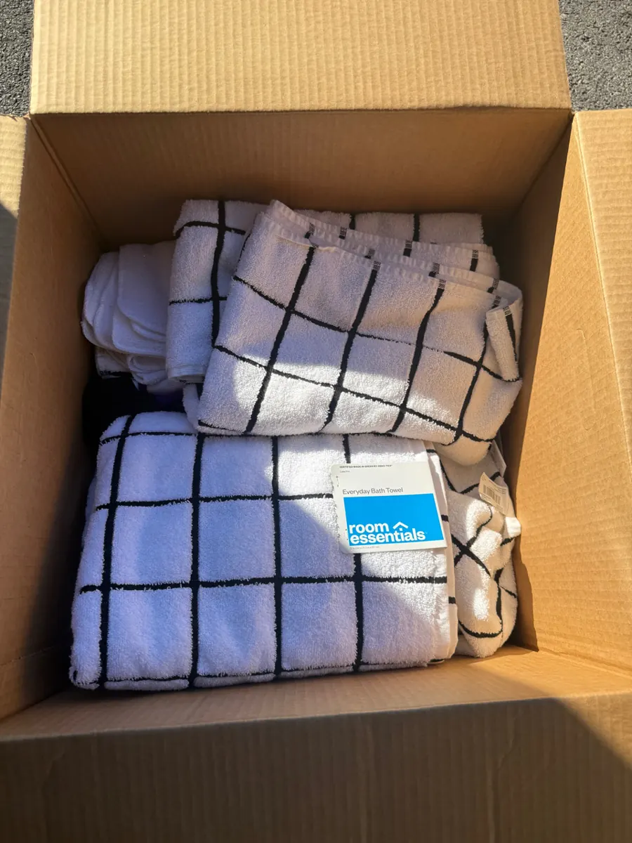 Folded towels packed into a box during a contents pack-out in Whitney