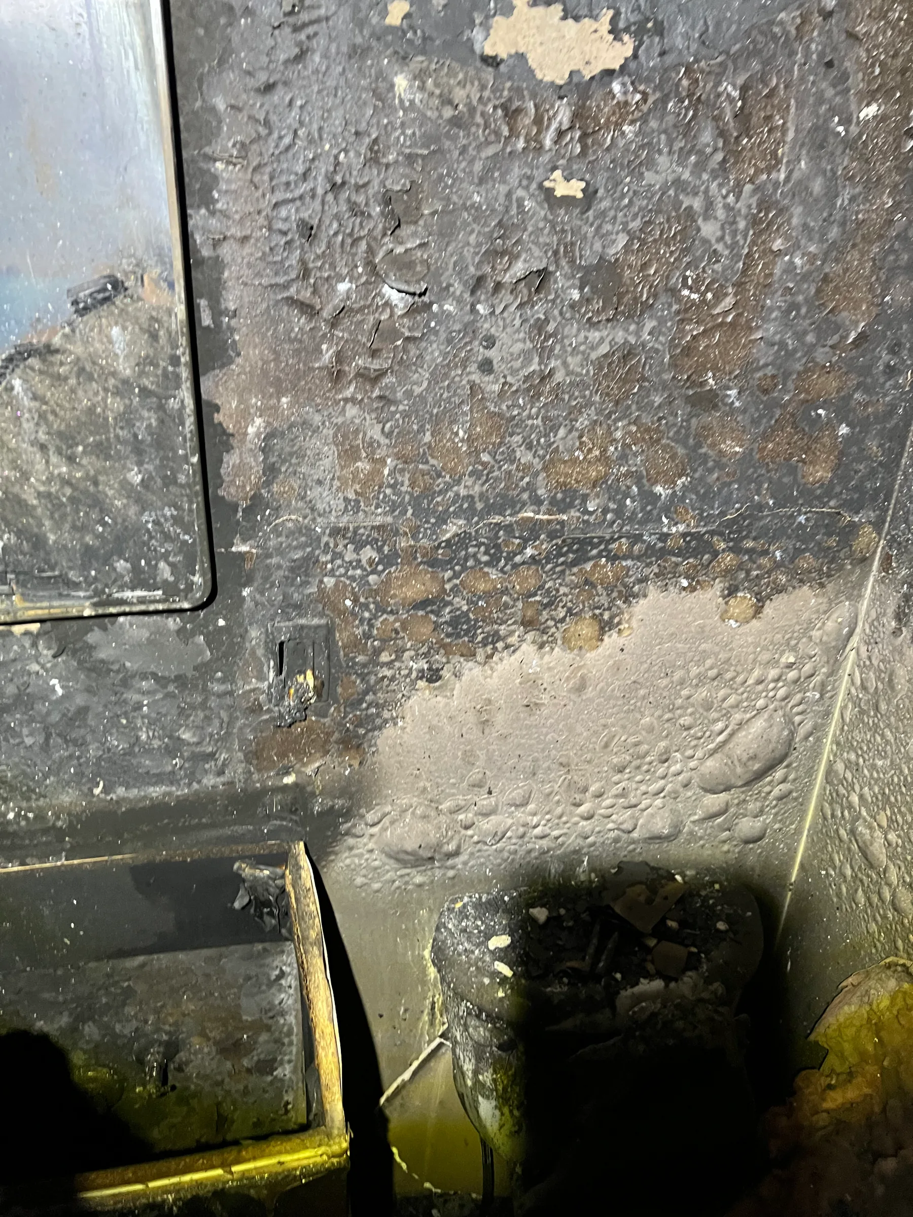 Close-up of soot and char damage across walls and flooring after fire