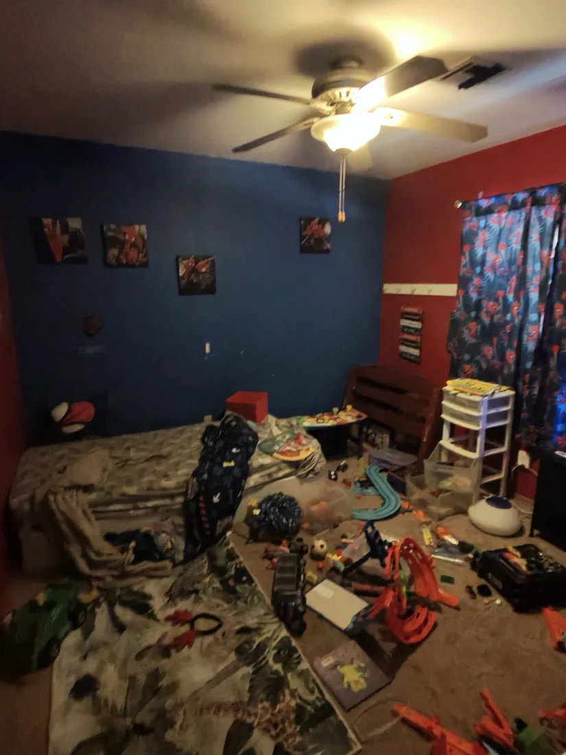 Hoarded bedroom with scattered belongings before sorting and cleanup in Henderson