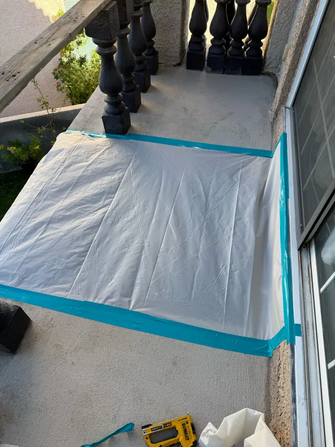 Opened balcony deck covered with taped plastic sheeting to keep out weather