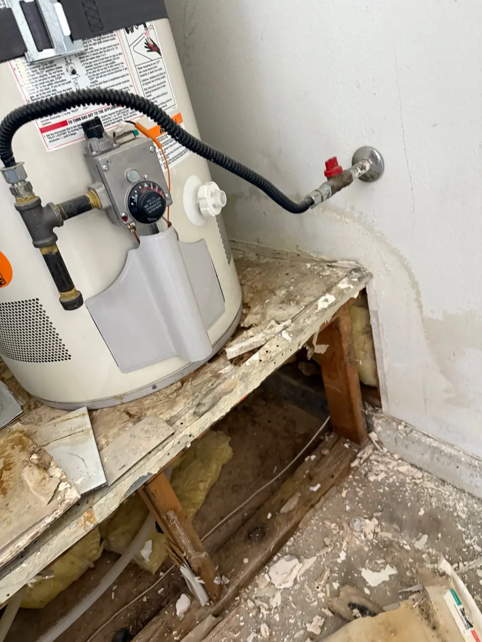 Water heater platform opened up after a slow leak left hidden moisture damage in the framing