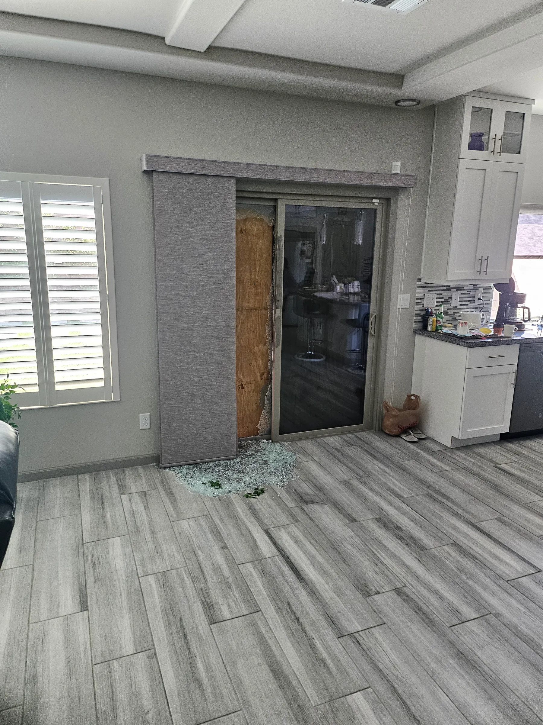 Interior view of glass door damage and board-up after vandalism