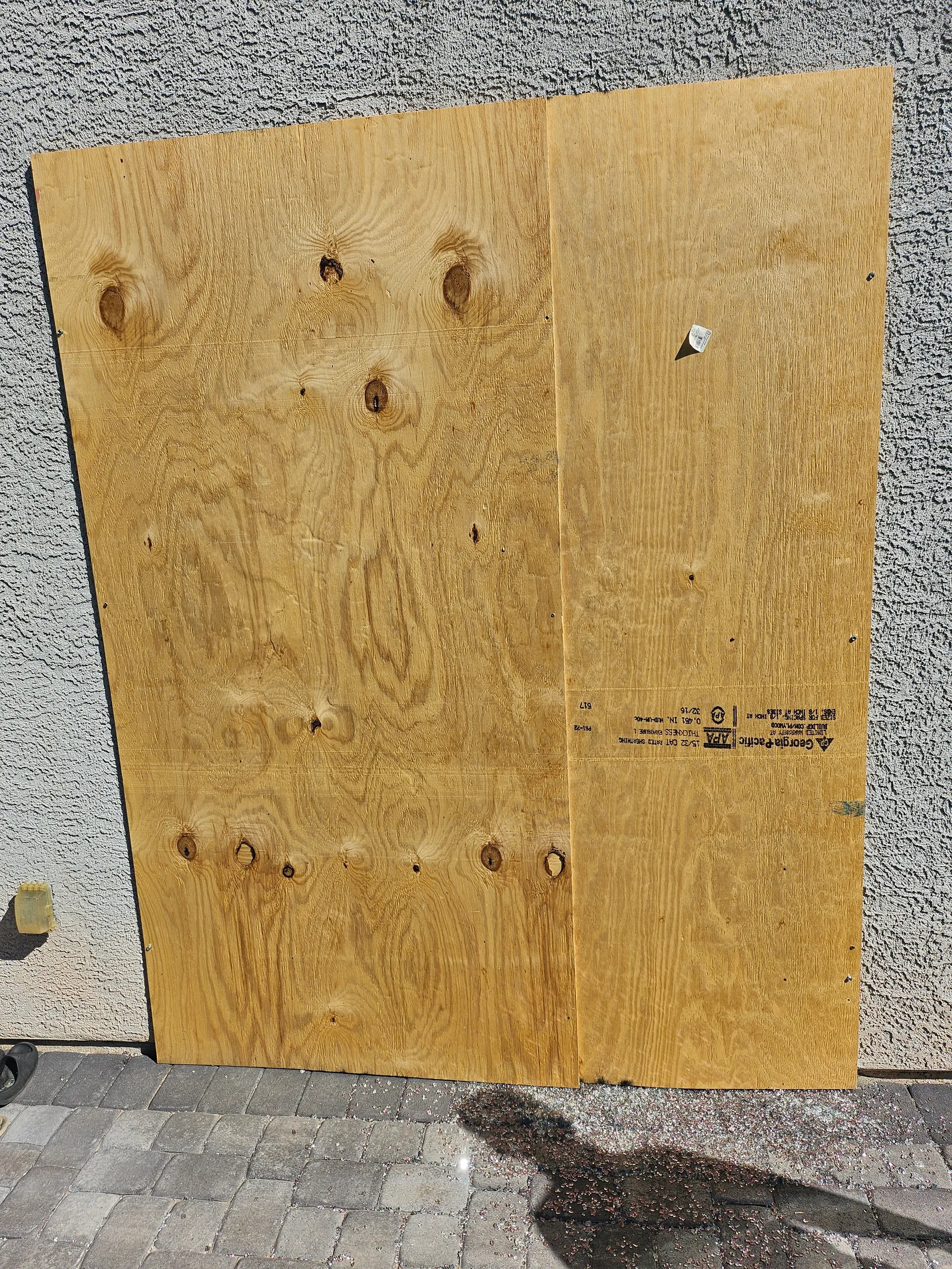 Plywood board-up securing a broken window after vandalism